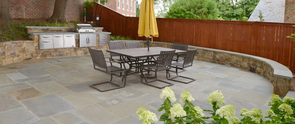 Patio in Chevy Chase, MD, with an outdoor kitchen and seating wall.