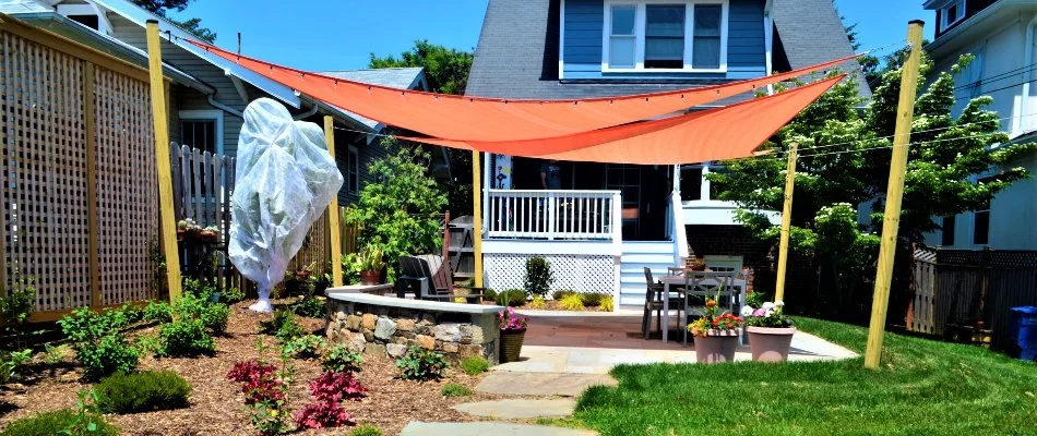 Backyard with shade sail and landscaping.