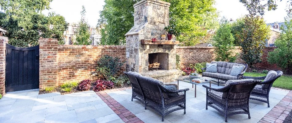 A patio with an outdoor fireplace on a property in Chevy Chase, MD.