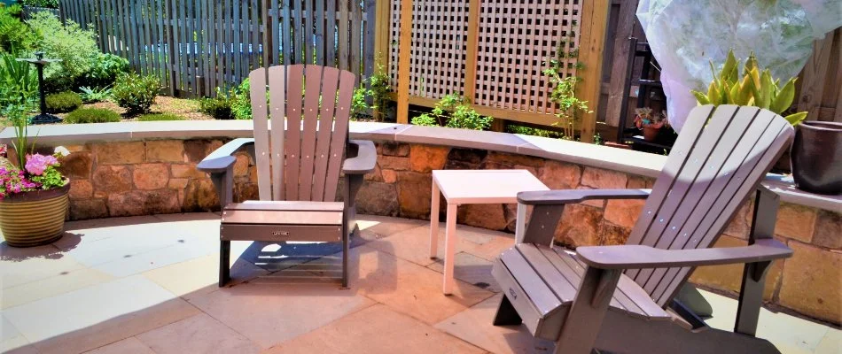 Tan seating wall beside two chairs and umbrella at a home in Chevy Chase, MD.