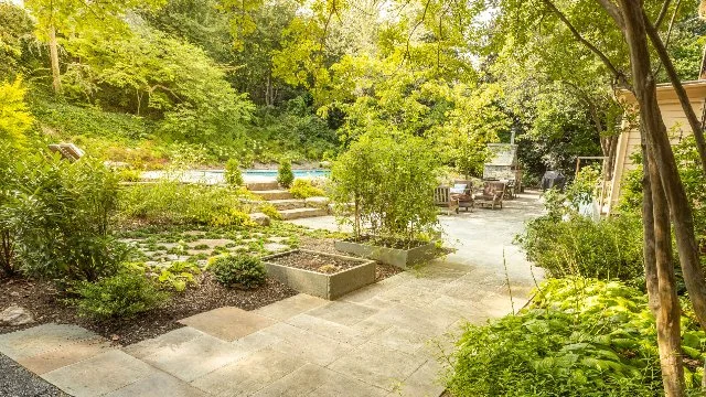 Planted garden area with patio, steps, and pool in Potomac, MD.